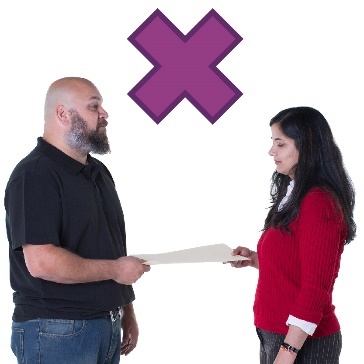 A person giving a document to someone else under a cross.