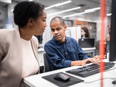 A person supporting someone else to use a computer.