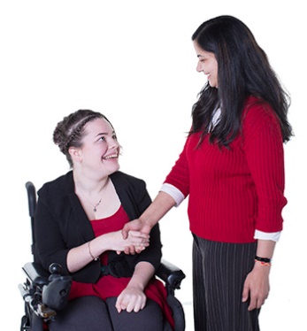 A woman in a wheelchair shaking hands with another woman