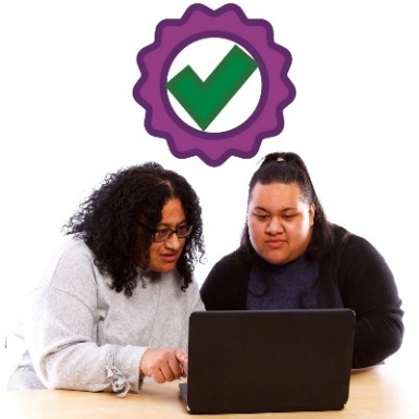 2 people looking at a laptop. Above is a quality icon.