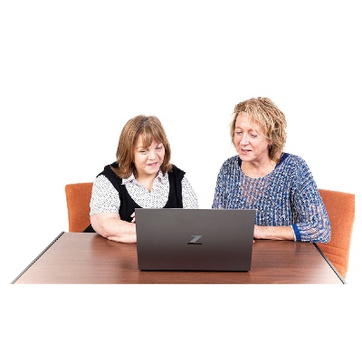 A person helping someone to use a computer.