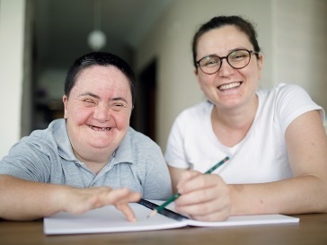 A worker supporting a participant to read.