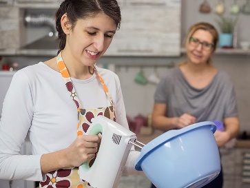 An NDIS worker supporting a participant to cook.