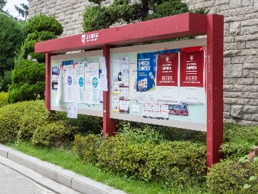 A notice board with posters on it.