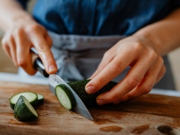 A support worker cutting vegetables.