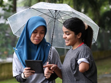 A person showing someone else information on an iPad.