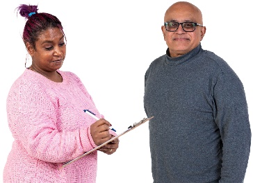 A person writing notes next to a worker.