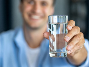 A participant holding out a glass of water.