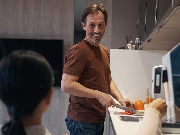 A worker cutting vegetables in a kitchen.