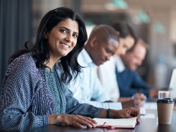 A group of people looking at documents in an office.