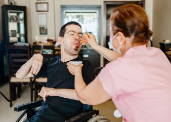 An NDIS worker supporting a participant to eat.