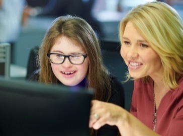 2 people looking at a computer together.