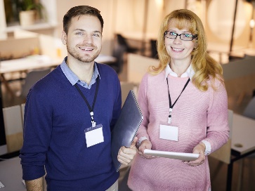 2 workers smiling in an office.