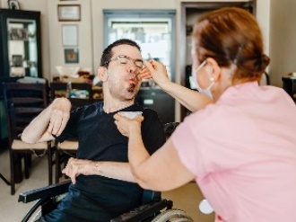 An NDIS worker supporting a participant to eat.