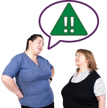 A participant and a worker having a conversation. Above the participant is an emergency icon in a speech bubble.