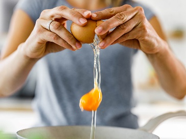 Aliya cracking an egg into a bowl.