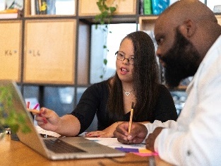 2 people looking at a laptop. 