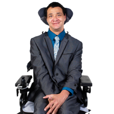 A person with disability dressed in office clothes. They are smiling.