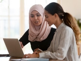 Two people looking at a laptop together. 