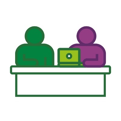 2 people sitting at a desk with a computer.