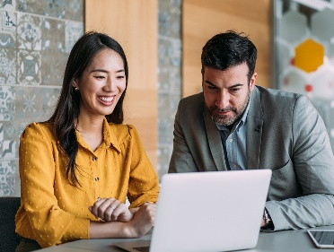 2 NDIS Commission chairs running a Forum meeting online using a laptop.