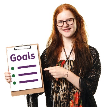 A young girl pointing to a list of goals. 